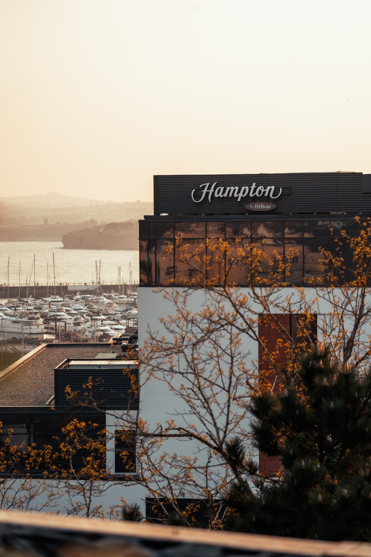 Hampton by Hilton Torquay above the harbour at sunset